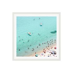 an aerial view of people on the beach and in the water, with small boats