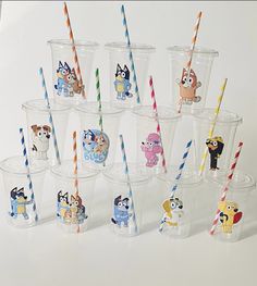 there are many plastic cups with cartoon characters on them and straws in each cup