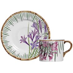 two plates and a cup with flowers painted on them, one has a bamboo rim