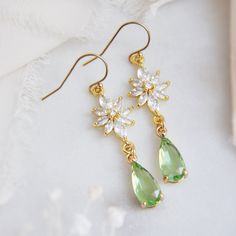 "Flower Earring // Light Green Earrings // Bridesmaids Earrings // Boho Bridal Earrings // Whimsical Earrings // Floral Drop Earrings // 14k Gold Filled Earrings These beautiful whimsical earrings are created with a unique cubic zirconia floral design. Secured to them are light green faceted glass teardrops. The flower earrings are secured to dainty 14k gold filled earring wires for a comfortable all day wear. Whether searching for green jewelry for your bridesmaids or unique floral earrings for your wedding day, all of my jewelry arrives suitably gift wrapped ready for gift giving. Measurements: The length of the dainty flower earrings hang a little over 1.5\" long Metals: 14k gold filled earring hooks 14k gold filled jump rings Gold plated cubic zirconia Gold plated teardrops Complete th