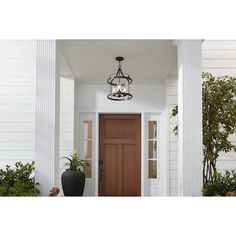 a light hanging from the side of a door next to a potted plant and vase