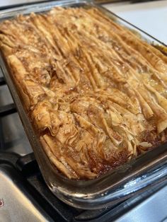 a casserole dish sitting on top of a stove in a glass baking pan