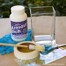 a bottle of paint, brush and glass container sitting on top of a wooden table