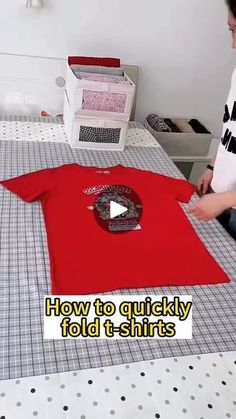 a person sitting at a table with a t - shirt on it and the words how to quickly fold t - shirts