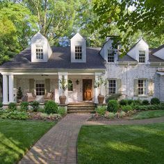 a large white house sitting on top of a lush green field