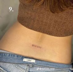 a woman's stomach with the word divine tattooed on her lower side ribcage