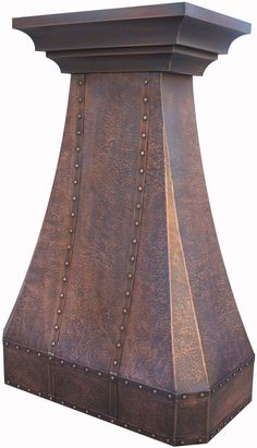 a large copper colored stove hood with rivets on the sides and an arched top