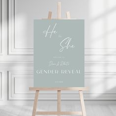 an easel with a sign on it that says he is she and the gender reveal