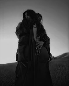 two women hugging each other in a field