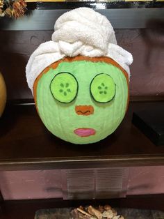 a pumpkin with a towel on top of it's head and eyes painted to look like a face