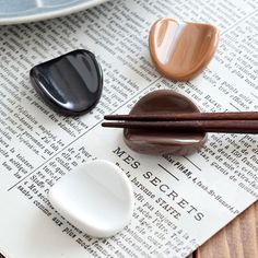 chopsticks are placed on top of an old newspaper with chocolate and marshmallows