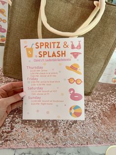 a hand holding up a pink and white sign that says spritz & splash