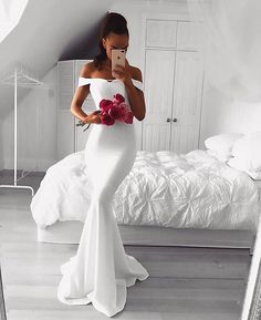 a woman taking a selfie in her white wedding dress