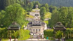 people are walking around in front of a large building with lots of greenery on it