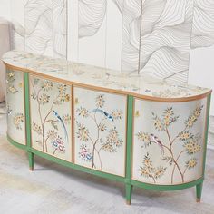 a white and green cabinet with birds painted on the front, sideboard or buffet