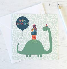 a birthday card with a green dinosaur holding a present