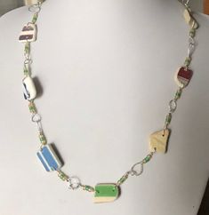 "This listing is for a beautiful necklace. I found these pieces of sea pottery on the beaches of East Coast Scotland. I have drilled and wire-wrapped them, using frosted yellow and green glass beads as accents. All of the metal used in this necklace is .925 sterling silver. The necklace measures 21\" from clasp to clasp.  My seaglass is a combination of Seaham seaglass, and Scottish seaglass - I usually collect from the East Coast of Scotland beaches, and the shores of Loch Tay. When time permits, I travel to the fantastic Seaham beach to scour its shores for finds. I ship worldwide with Royal Mail International Standard. If you would prefer extra security for your parcel, in the form of the Royal Mail International Signed For service, or if your country is not listed in my postage costs, Pottery Rainbow, Gold Pendants For Men, Purple Beach, Fire Opals Jewelry, Beach Necklace, Horse Necklace, Opal Pendant Necklace, Beach Necklaces, Sea Pottery