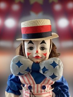 a creepy clown doll wearing a top hat and red white and blue outfit