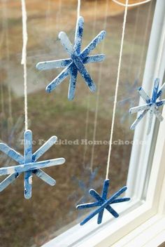 three snowflakes hanging from a window