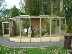 an outdoor gazebo in the middle of a park with trees and bushes around it