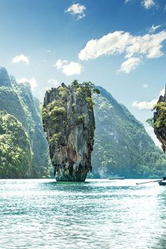 an island in the middle of water surrounded by mountains