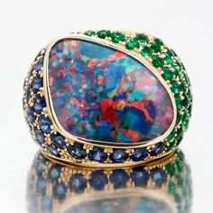 A true One of a Kind 9.98ct Irregular Shaped Boulder Mosaic Pattern Black Opal adorned with 50 Sandawana Emeralds=2.36ctw and 31 Pailin Sapphires=4.58ctw in 18kt Yellow Gold Cigar Ring. Total weight of ring is 15.5 grams. Currently a Finger Size 6.5, Can be sized to Fit you! We dreamed this up and made it happen! Sapphire Cocktail Ring, Black Opal Ring, Gold Cocktail Ring, Gorgeous Jewelry, Gems And Minerals, Boulder Opal, Black Opal, Opal Jewelry, Cocktail Ring