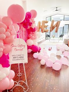 pink and white balloons are on the floor in front of a sign that reads, she's getting married welcome to her celebration