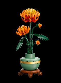 a green vase with orange flowers in it on a wooden stand against a black background