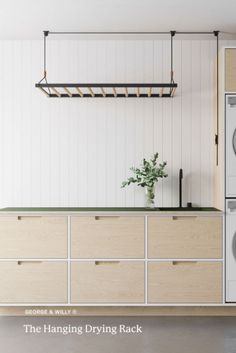 the hanging drying rack is next to a washer and dryer in a kitchen