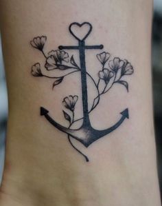 a small anchor with flowers on the side of her leg and a heart in the middle