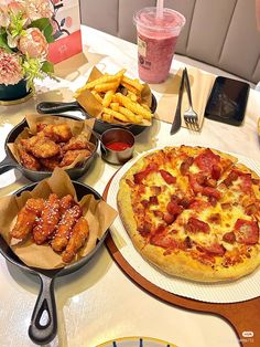 a table topped with pizza and other foods