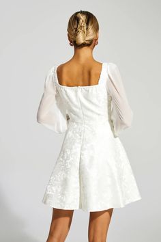 the back of a woman wearing a white dress