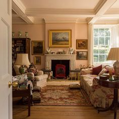 a living room filled with furniture and a fire place in the middle of a room