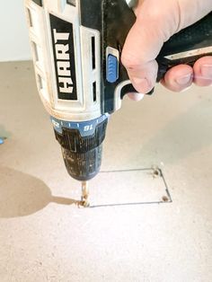 a person using a drill to fix a hole in the floor