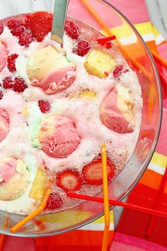 a bowl filled with ice cream and strawberries on top of a colorful table cloth