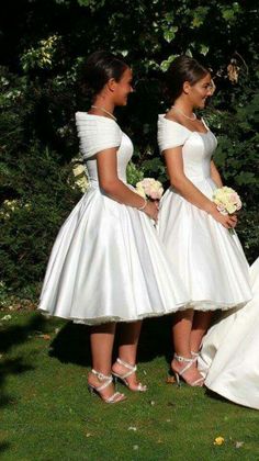 two women in white dresses standing next to each other