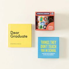 two books and a box with magnets on them sitting next to each other in front of a white wall