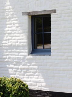 a white brick building with a blue window