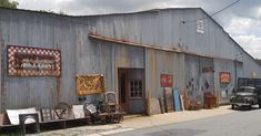 an old metal building with lots of junk outside