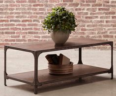 a potted plant sitting on top of a wooden table next to a brick wall