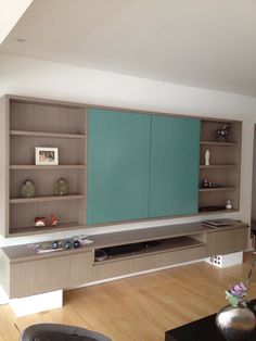 a living room with a large entertainment center next to a wall mounted flat screen tv