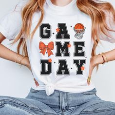 Basketball Game Day Shirt with Coquette Basketball Bow & Basketball Hoop Elevate your game day style with our Basketball Game Day Shirt featuring a charming Basketball Bow and Basketball Hoop design. This tshirt seamlessly combines sporty elements with feminine flair, addressing the lack of basketball-themed clothing with chic design details. Crafted entirely from ring-spun cotton, this shirt offers a luxurious feel against your skin. The soft-washed, garment-dyed fabric not only adds a cozy touch to your wardrobe but also ensures long-lasting comfort. The double-needle stitching enhances durability while the lack of side-seams maintains the shirt's sleek tubular shape. Designed with a classic crew neckline, this shirt offers a neat and timeless look that's perfect for accessorizing. The p Basketball Manager Shirts, Basketball Shirt Designs, Basketball Mom Shirts, Basketball Tees, Game Day Outfit, Basketball Mom, Hoop Design, Basketball Shirts, Basketball Game