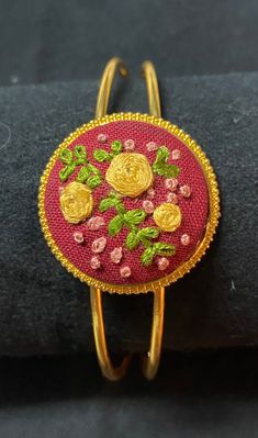 Hand embroidered golden roses. The embroidered piece is placed in a gold cuffed bracelet. The gold bracelet metal can be bent in or out to fit any sized wrist. Gold Embroidered Bracelets For Wedding, Elegant Embroidered Bracelets As Gift, Elegant Embroidered Bracelets As A Gift, Gold Embroidered Bangle Bracelet, Adjustable Embroidered Bangle Bracelet, Gold Jewelry With Floral Embroidery For Gift, Embroidered Christmas Ornaments, Golden Roses, Embroidered Bracelet