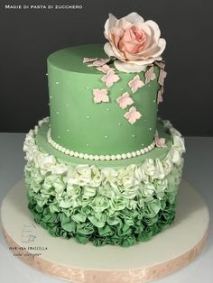 a green and white cake with flowers on top