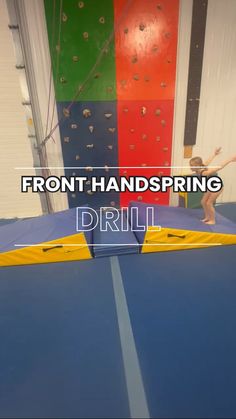 an indoor climbing wall with the words front handspring drill