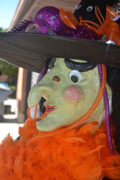 a close up of a person wearing a costume and hat with orange feathers on it