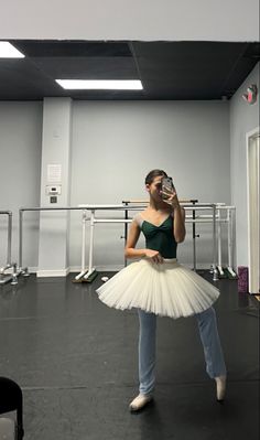 a woman in a white tutu is taking a selfie with her cell phone