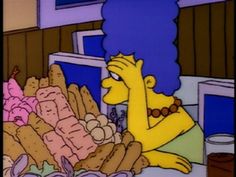 the simpsons is sitting in front of a pile of bread and doughnuts, with her hand on her face