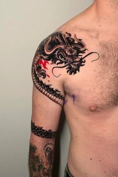 a man with a dragon tattoo on his arm and chest is posing for the camera