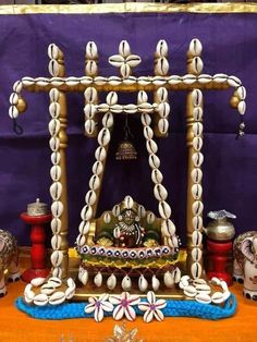 an elaborately decorated shrine with bells and decorations on the table in front of a purple backdrop